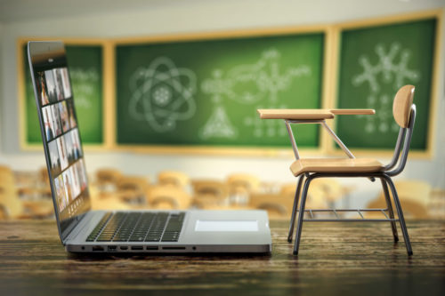 Laptop and school desk on blackdesk in classroom.  Online educat